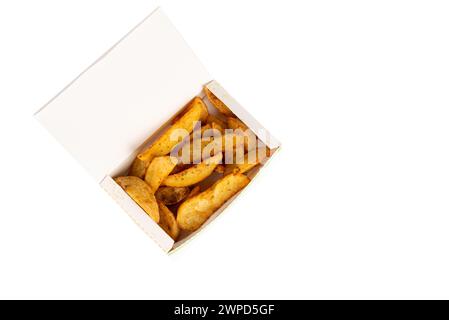 patate fritte a spicchi in una scatola di cartone bianca isolata su sfondo bianco. Vista dall'alto. patate al forno con spicchi in un involucro di carta. concetto di cibo da asporto Foto Stock