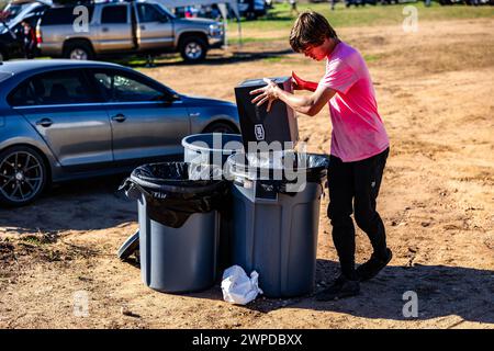 Un uomo che smista i rifiuti in tre contenitori di riciclaggio in occasione di un evento a Burnet, Stati Uniti Foto Stock