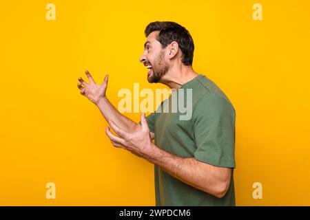 Ritratto fotografico di un giovane uomo attraente arrabbiato urla urla irritato vestiti eleganti cachi isolati su sfondo giallo Foto Stock