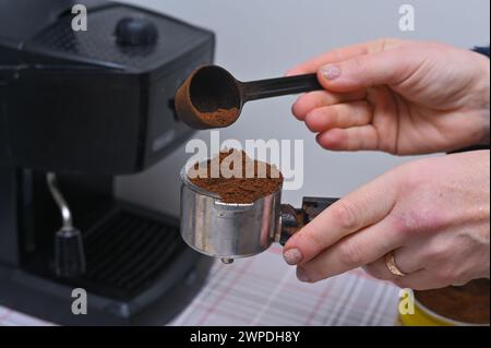 le mani delle donne versano un caffè profumato nella macchina da caffè Foto Stock