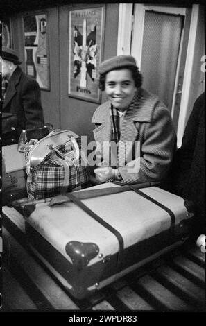 Fotografia che mostra il controllo del passaporto e dei bagagli presso la stazione estera dell'aeroporto di Varsavia, scattata da Wiesław Prażuch nel 1959 come parte del "Please Open!" serie di fotogiornalismo, che documenta le procedure doganali e le interazioni dei viaggiatori. Foto Stock