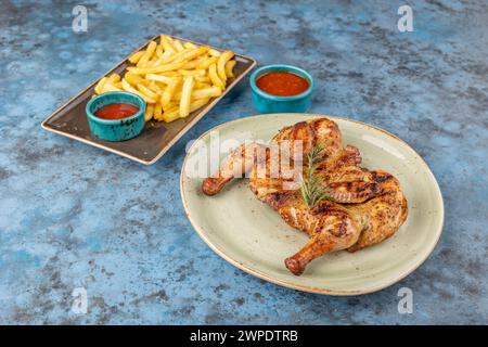 Tabaka di pollo arrosto fritto alla griglia, patatine fritte e ketchup su piatti su sfondo blu. Vista dall'alto Foto Stock