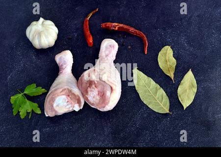 Su uno sfondo nero si trovano due cosce di pollo pronte per la cottura. Foto Stock