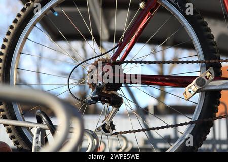 Ruota posteriore per biciclette con parcheggio per biciclette a ingranaggi presso la stazione ferroviaria centrale di Farnborough con portabiciclette, Farnborough, Hampshire, Regno Unito Foto Stock