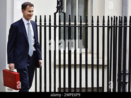 Inghilterra, Londra, Westminster, Jeremy Hunt, Cancelliere conservatore dello Scacchiere, che tiene la scatola rossa di spedizione a Downing Street durante il giorno di bilancio 2024. Foto Stock