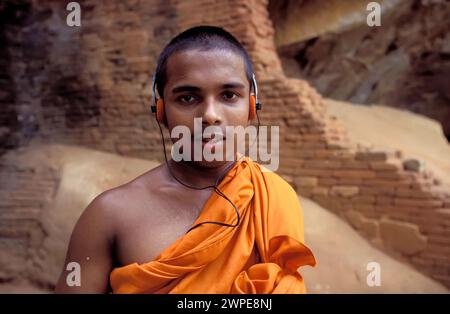 Sri Lanka, Sigeria; Un monaco buddista ascolta musica. Foto Stock
