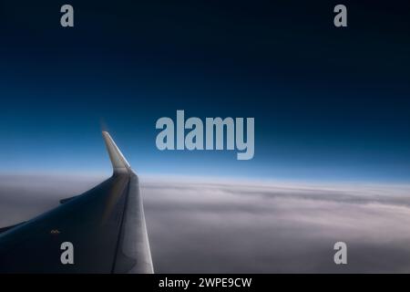 Ala di un aeroplano ad una grande altezza contro un cielo azzurro e nuvoloso. Banner orizzontale utile Foto Stock