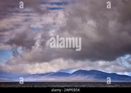 Sotto un cielo pesante e prepotente, Mull appare attraverso la nebbia di Ganavan Sands di Oban. Scozia Foto Stock