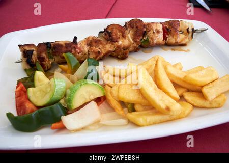 Pasto con kebab di pollo e patatine fritte in un ristorante Costa Teguise, Lanzarote, Isole Canarie, spagna Foto Stock