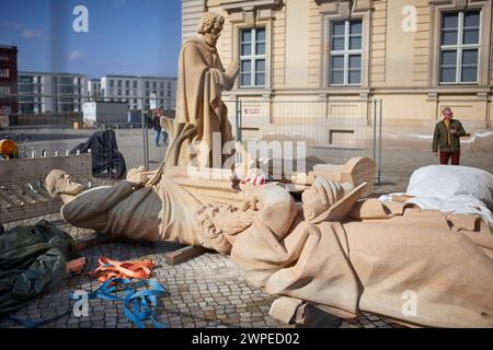 Vorbereitungen fuer die Anbringung der Propheten-Statuen an der Kuppel des Humboldt-Forum a Berlin-Mitte: Mitarbeiter des Bamberger Natursteinwerk Hermann Graser stellen AM 7. Maerz 2024 acht Figuren vor dem Nachbau des ehemaligen Stadtschlosses auf. Im foto vom 07.03.2024: Die Figuren des Hesekiel liegend vorne und des Zacharias liegend sowie des Jonas stehend. DAS Berliner Humboldt Forum erhaelt acht weitere Balustradenskulpturen. An der Westseite werden im Zuge der letzten Rekonstruktionsarbeiten Mitte Maerz acht Propheten-Figuren auf der Kuppel-Balustrade montiert, teilte die Stiftung Hum Foto Stock