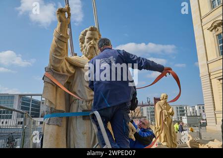 Vorbereitungen fuer die Anbringung der Propheten-Statuen an der Kuppel des Humboldt-Forum a Berlin-Mitte: Mitarbeiter des Bamberger Natursteinwerk Hermann Graser stellen AM 7. Maerz 2024 acht Figuren vor dem Nachbau des ehemaligen Stadtschlosses auf. Im foto vom 07.03.2024: Mitarbeiter des Natursteinwerk stellen die Figur des Jesaja auf. DAS Berliner Humboldt Forum erhaelt acht weitere Balustradenskulpturen. An der Westseite werden im Zuge der letzten Rekonstruktionsarbeiten Mitte Maerz acht Propheten-Figuren auf der Kuppel-Balustrade montiert, teilte die Stiftung Humboldt-Forum di Berlino Foto Stock