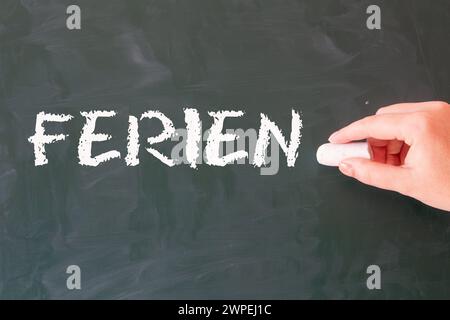 La parola tedesca FERIEN (vacanze) è scritta su una lavagna scolastica (immagine simbolo) Foto Stock