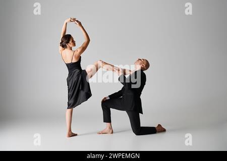 Danza graziosa di giovani coppie che si esibiscono insieme in studio con sfondo grigio Foto Stock