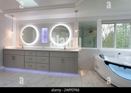 Bagno principale spazioso, moderno e moderno, con lavandino, parete e mensola con luci Foto Stock