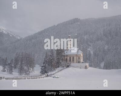 Questa immagine invernale è della chiesa di San Nicola situata nel villaggio di Obernberg, in cima alla valle di Obernbergtal, nel Tirolo austriaco Foto Stock