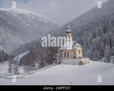 Questa immagine invernale è della chiesa di San Nicola situata nel villaggio di Obernberg, in cima alla valle di Obernbergtal, nel Tirolo austriaco Foto Stock