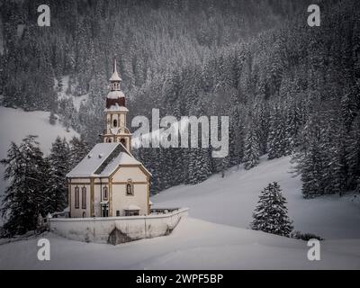 Questa immagine invernale è della chiesa di San Nicola situata nel villaggio di Obernberg, in cima alla valle di Obernbergtal, nel Tirolo austriaco Foto Stock