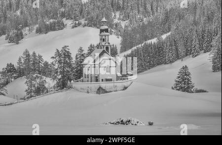 Questa immagine invernale è della chiesa di San Nicola situata nel villaggio di Obernberg, in cima alla valle di Obernbergtal, nel Tirolo austriaco Foto Stock