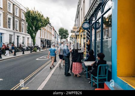 Londra, Regno Unito - 26 agosto 2023: Scena di strada con caffè marciapiede nella zona di Portobello Road a Notting Hill Foto Stock