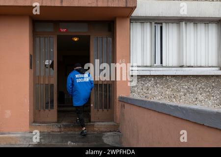 Marsiglia, Francia. 15 febbraio 2024. Un membro dei servizi di mediazione sociale della città di Marsiglia entra in un edificio nel complesso residenziale Kalliste nei distretti settentrionali di Marsiglia, in Francia, il 15 febbraio 2024. Foto di Laurent Coust/ABACAPRESS.COM credito: Abaca Press/Alamy Live News Foto Stock