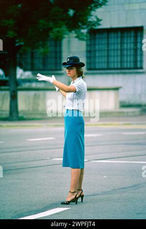 Giovane agente del traffico donna che dirige il traffico nel centro della città nel 1980, Basilea, Svizzera Foto Stock