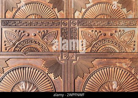 Antichi gradini in ghisa con ornamenti sulla strada della città. Scale in metallo vintage decorate con motivi eleganti all'aperto. Punto di riferimento storico Foto Stock