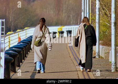 Glasgow, Scozia, Regno Unito. 7 marzo 2024: Regno Unito Meteo: Donna asiatica sulla passerella clyde accanto al fiume clyde. Il sole in città ha visto la gente del posto e i turisti sulle strade del centro città. Il passaggio pedonale clyde all'hotel plaza. Credit Gerard Ferry/Alamy Live News Foto Stock