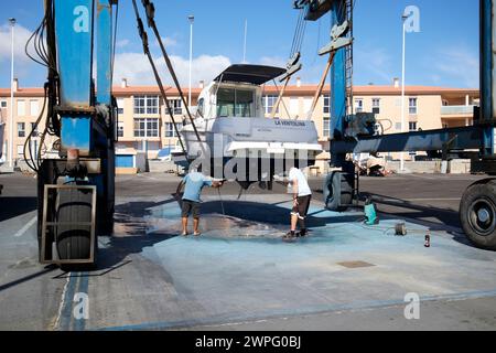 Pulizia della parte inferiore di una barca su un ascensore nel porto turistico di Corralejo, fuerteventura, Isole Canarie, spagna Foto Stock
