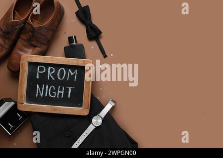 Lavagna con testo PROM NIGHT, scarpe e pantaloni maschili su sfondo marrone Foto Stock