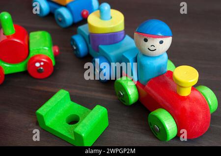 Blocchi in legno multicolore sotto forma di treno con un conducente, attenzione selettiva. Giocattoli educativi Foto Stock