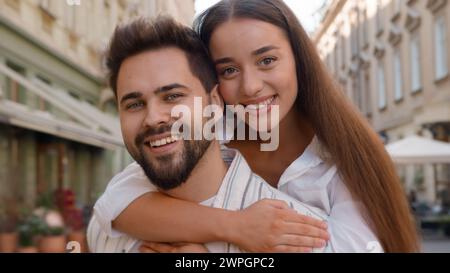 Felice giovane coppia caucasica uomo donna coccolante abbraccio abbraccio insieme amore godere sorriso famiglia luna di miele fuori legame città tenero strada Foto Stock