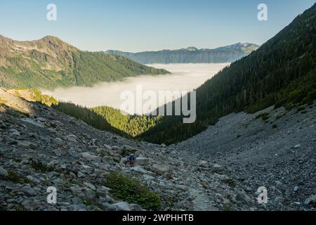 L'escursionista si arrampica attraverso il Rocky Field del Blue Glacier Trail nell'Olympic National Park Foto Stock