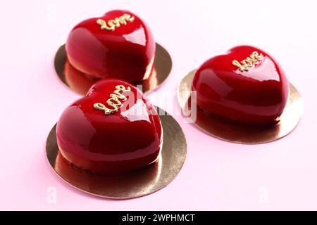 St San Valentino. Deliziose torte a forma di cuore su sfondo rosa chiaro, primo piano Foto Stock