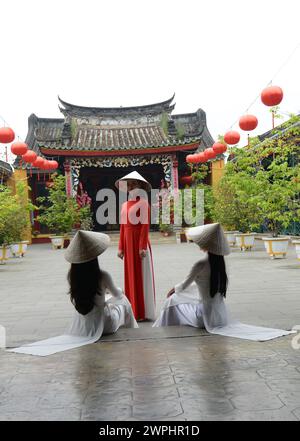 Modelle vietnamite in una foto al tempio buddista Hoa Van le Nghia nella città vecchia di Hoi An, Vietnam. Foto Stock