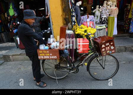 Un uomo che vende bevande dal suo banco di biciclette mobili. Città vecchia di Hoi An, Vietnam. Foto Stock