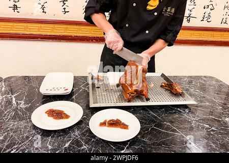 Pechino, Cina. 9 dicembre 2023. Uno chef prepara l'anatra arrosto al Quanjude Roast Duck Restaurant a Pechino, Cina, il 9 dicembre 2023. Quanjude è una catena di ristoranti nota per la sua anatra arrosto alla pechinese. (Foto di Samuel Rigelhaupt/Sipa USA) credito: SIPA USA/Alamy Live News Foto Stock