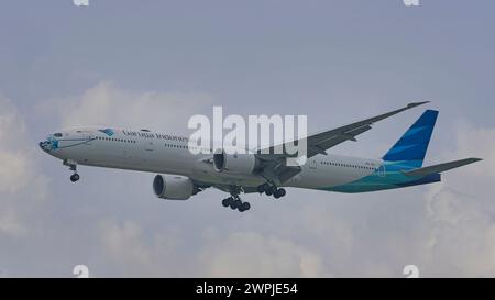 SINGAPORE - 8 MARZO 2024: Garuda Indonesia B777-3U3(ER), PK-GIJ Ayo Pakai Masker Livery avvicinamento finale all'aeroporto internazionale di Changi Foto Stock