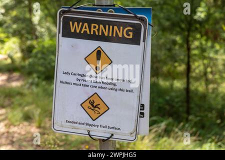 Lady Carrington Drive nel Royal National Park, cartello con la scritta "sollecita attenzione a causa delle recenti inondazioni improvvise, Sydney, NSW, Australia" Foto Stock