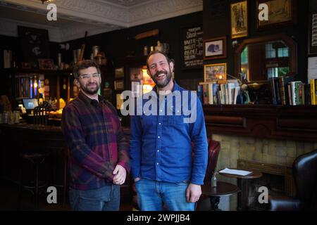 Ben Martin (a destra) e Tom Rees, co-proprietari della Carlton Tavern a Maida vale, Londra, che hanno dovuto ricostruire il loro pub dopo che è stato demolito illegalmente nel 2015. Ricostruire un pub dalle macerie è un compito difficile, ma è uno che Ben e Tom hanno trovato estremamente gratificante. Il pub Crooked House di Dudley affronta un futuro simile dopo che è stato distrutto in un incendio sospetto nell'agosto 2023. Data foto: Giovedì 29 febbraio 2024. Foto Stock