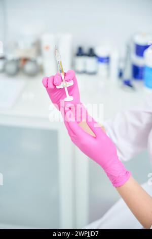 Foto ravvicinata di una donna che tiene in mano lo strumento per le iniezioni Foto Stock