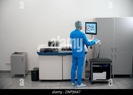 L'uomo in uniforme lavora su attrezzature moderne Foto Stock