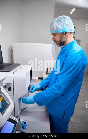 Lo specialista lavora su apparecchi per l'estrazione automatica di acidi nucleici Foto Stock
