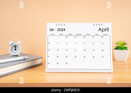 Aprile 2024, calendario mensile della scrivania per 2024 anni su tavolo di legno con diario. Foto Stock