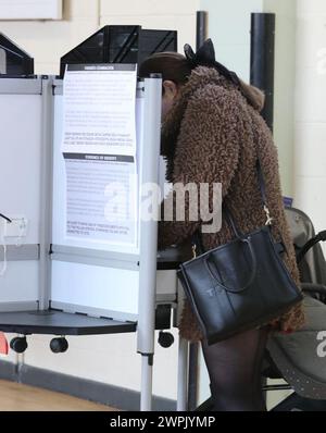 Voto in corso presso la Old St Josephs Gym Hall di Dublino, mentre l'Irlanda tiene referendum sulle modifiche proposte al testo della Costituzione relative alle aree di famiglia e cura. L'emendamento sulla famiglia propone di estendere il significato di famiglia al di là di quello definito dal matrimonio e di includere quelli basati su relazioni "durature”. L'emendamento Care propone di eliminare i riferimenti ai ruoli e ai doveri di una donna in casa e di sostituirlo con un nuovo articolo che riconosce gli assistenti familiari. Data foto: Venerdì 8 marzo 2024. Foto Stock