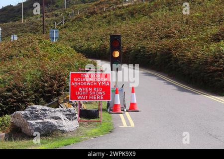 Controllo automatico del traffico che consente movimenti unidirezionali attraverso alcuni lavori stradali all'ingresso di un parcheggio pubblico vicino alla spiaggia di Ogmore. Foto Stock