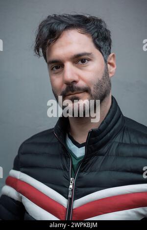Ritratto di un uomo sicuro di sé in un'elegante giacca a piumino: Stile urbano ed eleganza maschile combinati Foto Stock