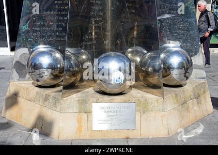 Palle d'argento alla base della scultura Exeter Riddle lungo High Street nel centro della città, Exeter, Devon, Regno Unito, Europa. Foto Stock