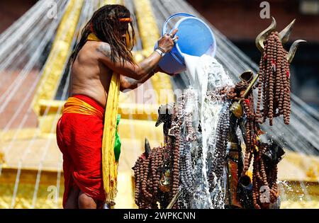 Kathmandu, Nepal. 8 marzo 2024. Un sacerdote adorna l'idolo del Signore Shiva con latte, segnando la festa sacra Maha Shivaratri celebrata con fervore e devozione dai devoti a Kathmandu, Nepal, venerdì 8 marzo 2024. Credito: SOPA Images Limited/Alamy Live News Foto Stock