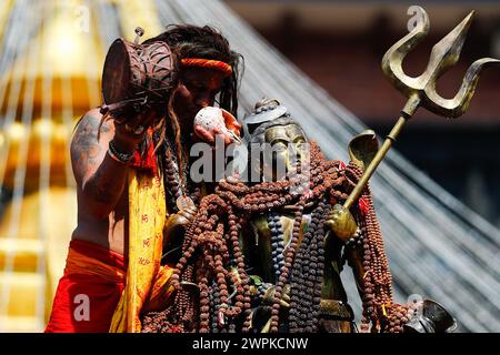 Kathmandu, Nepal. 8 marzo 2024. Un sacerdote soffia una ghianda accanto all'idolo del Signore Shiva, segnando la festa sacra Maha Shivaratri celebrata con fervore e devozione dai devoti a Kathmandu. Credito: SOPA Images Limited/Alamy Live News Foto Stock