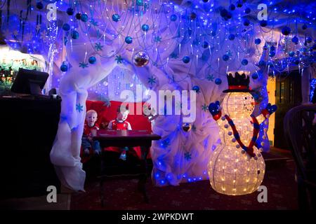 28/11/14 Jacob (2) e Reuben (3) si trovano nell'angolo del pub che è stato trasformato nella grotta di Babbo Natale. Il pub Hanging Gate a Chapel en le Frith, in th Foto Stock